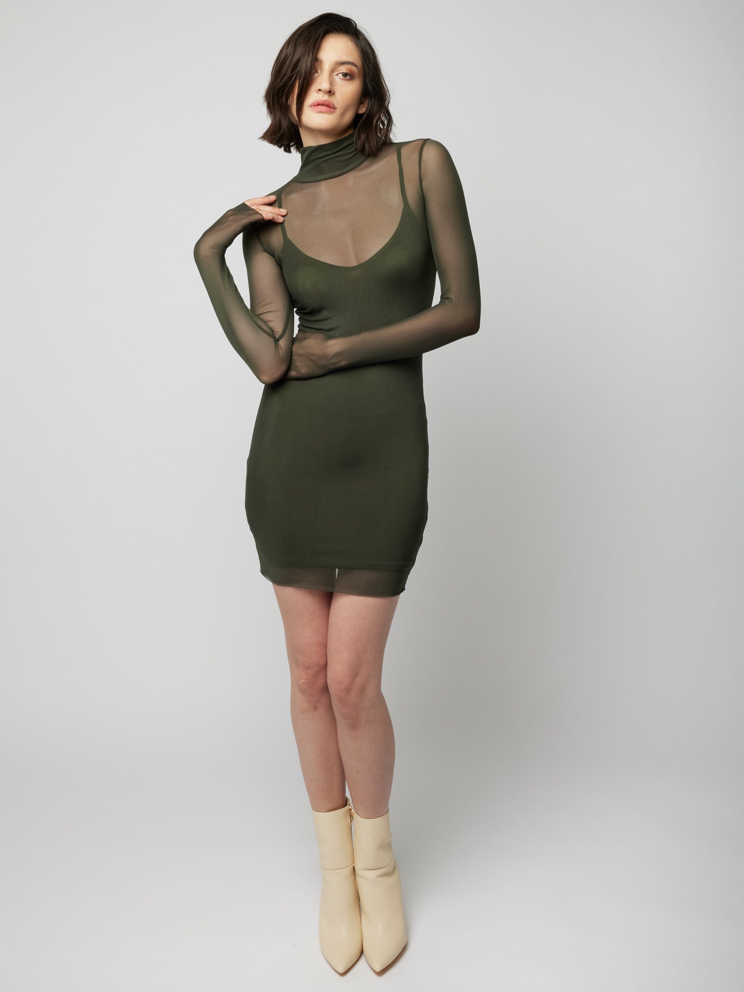 figure hugging, long sleeve mini dress with a sheer mock neck, sheer long sleeves with a spaghetti strap slip lining in olive