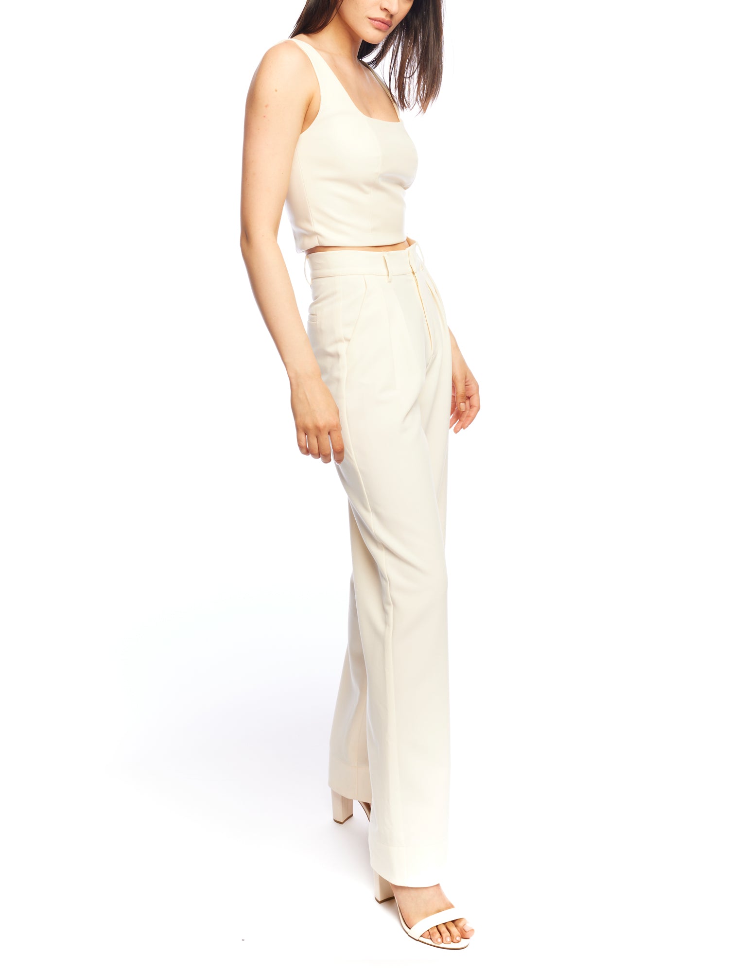 Mid-rise, wide leg pants with pleated front, side pockets, faux back pockets and belt loops in ivory