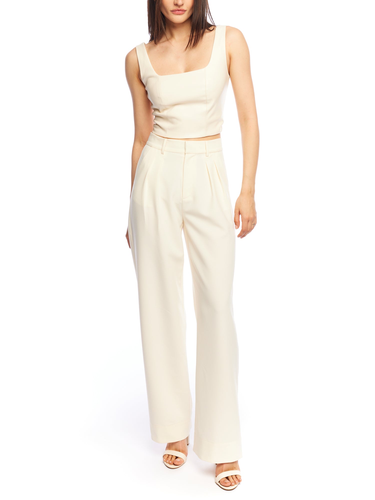 Mid-rise, wide leg pants with pleated front, side pockets, faux back pockets and belt loops in ivory