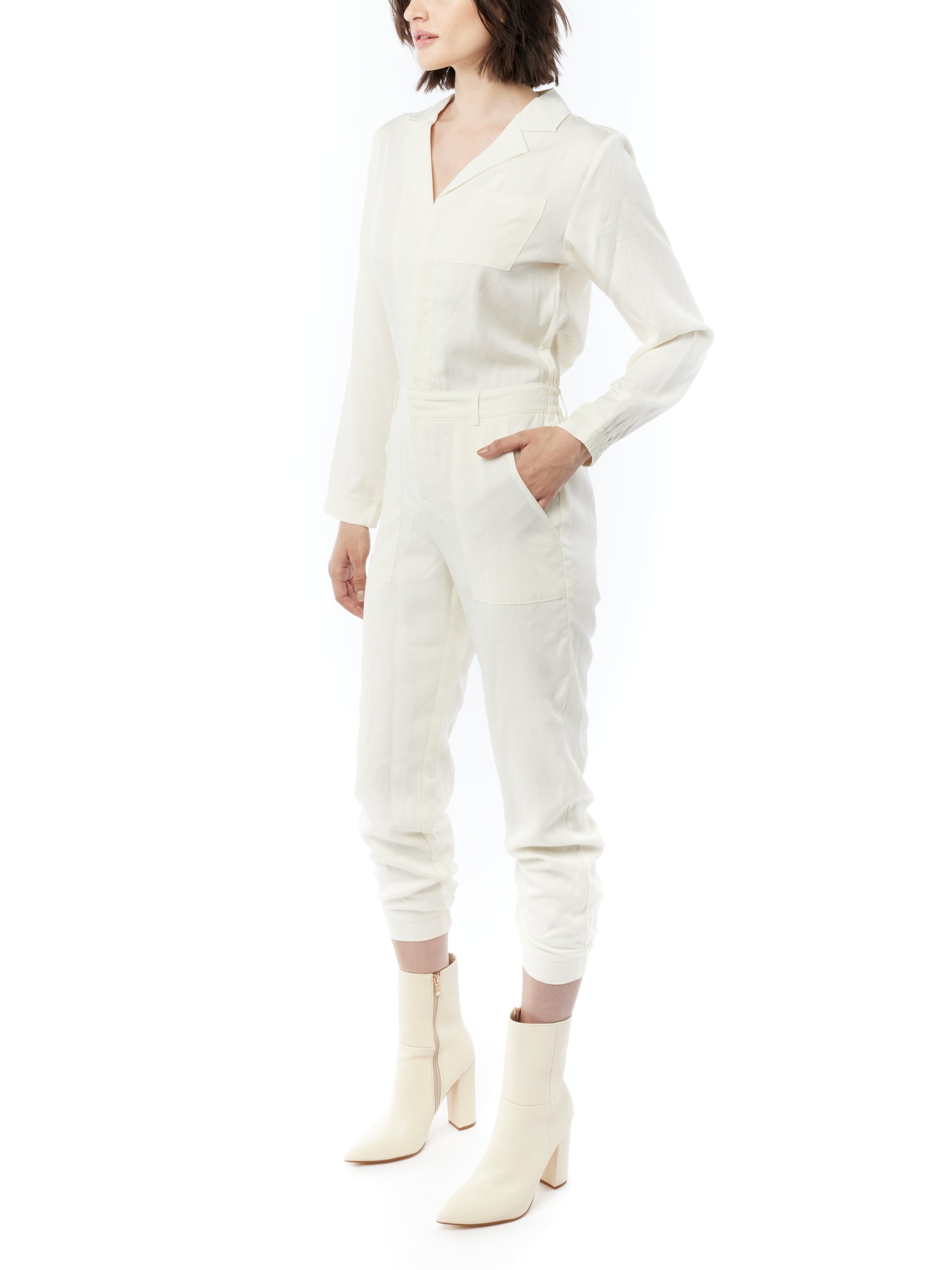 jumpsuit featuring a collared, button-front, long, cuffed sleeves, elasticized waist and bottom cuffs in ivory