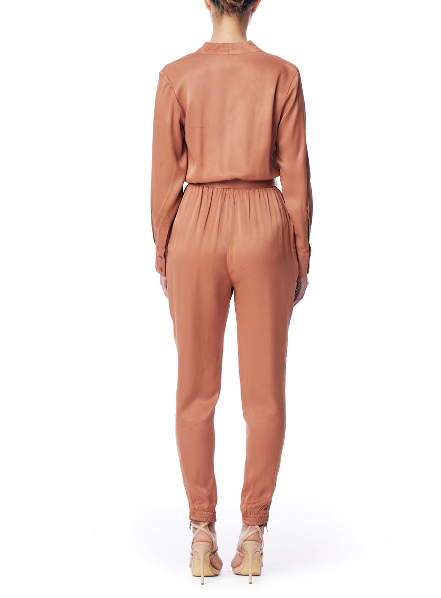 vegan silk jumpsuit with a cross over front, tapered leg, long sleeves, tie waist & side pockets