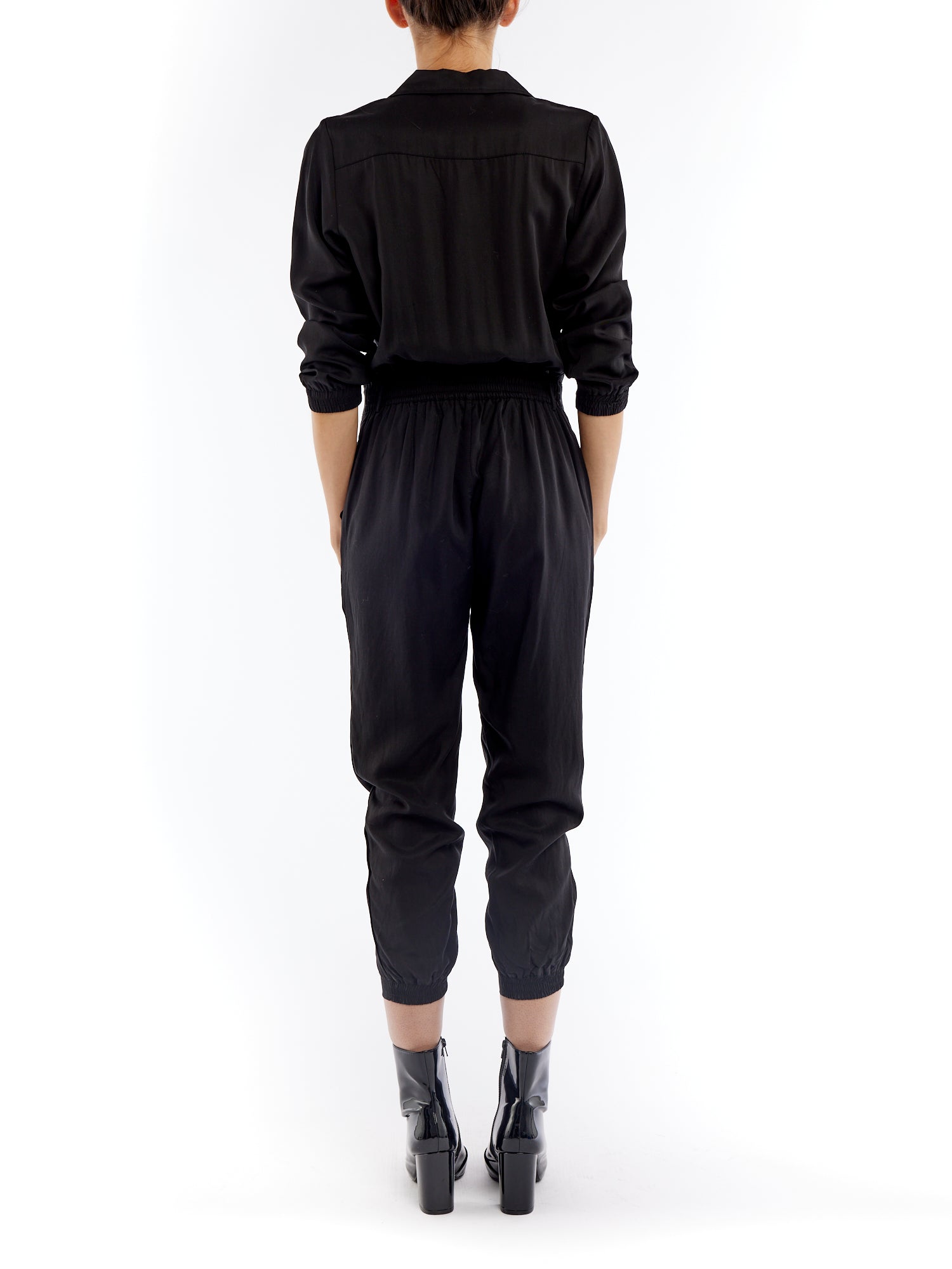jumpsuit featuring a collared, button-front, long, cuffed sleeves, elasticized waist and bottom cuffs in black
