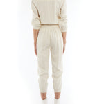 jumpsuit featuring a collared, button-front, long, cuffed sleeves, elasticized waist and bottom cuffs in ivory