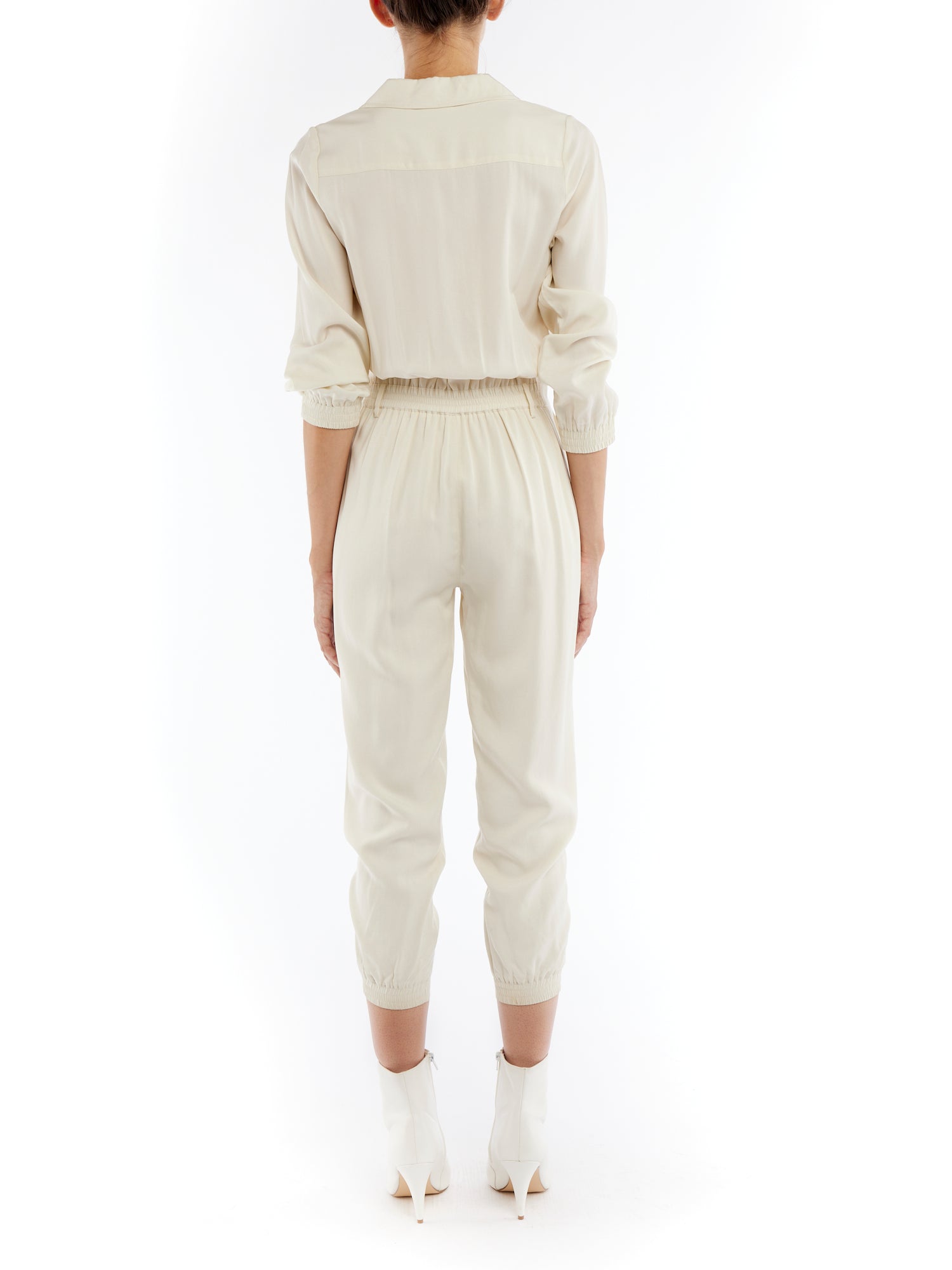 jumpsuit featuring a collared, button-front, long, cuffed sleeves, elasticized waist and bottom cuffs in ivory